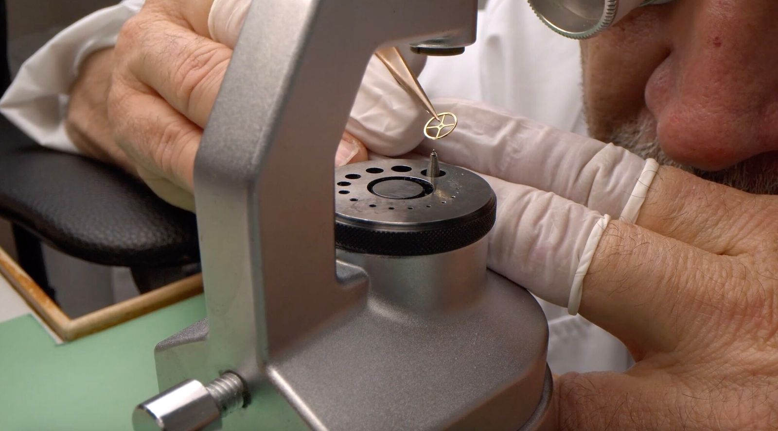 Watchmaker performing modern micro-regulation on a mechanical watch balance wheel